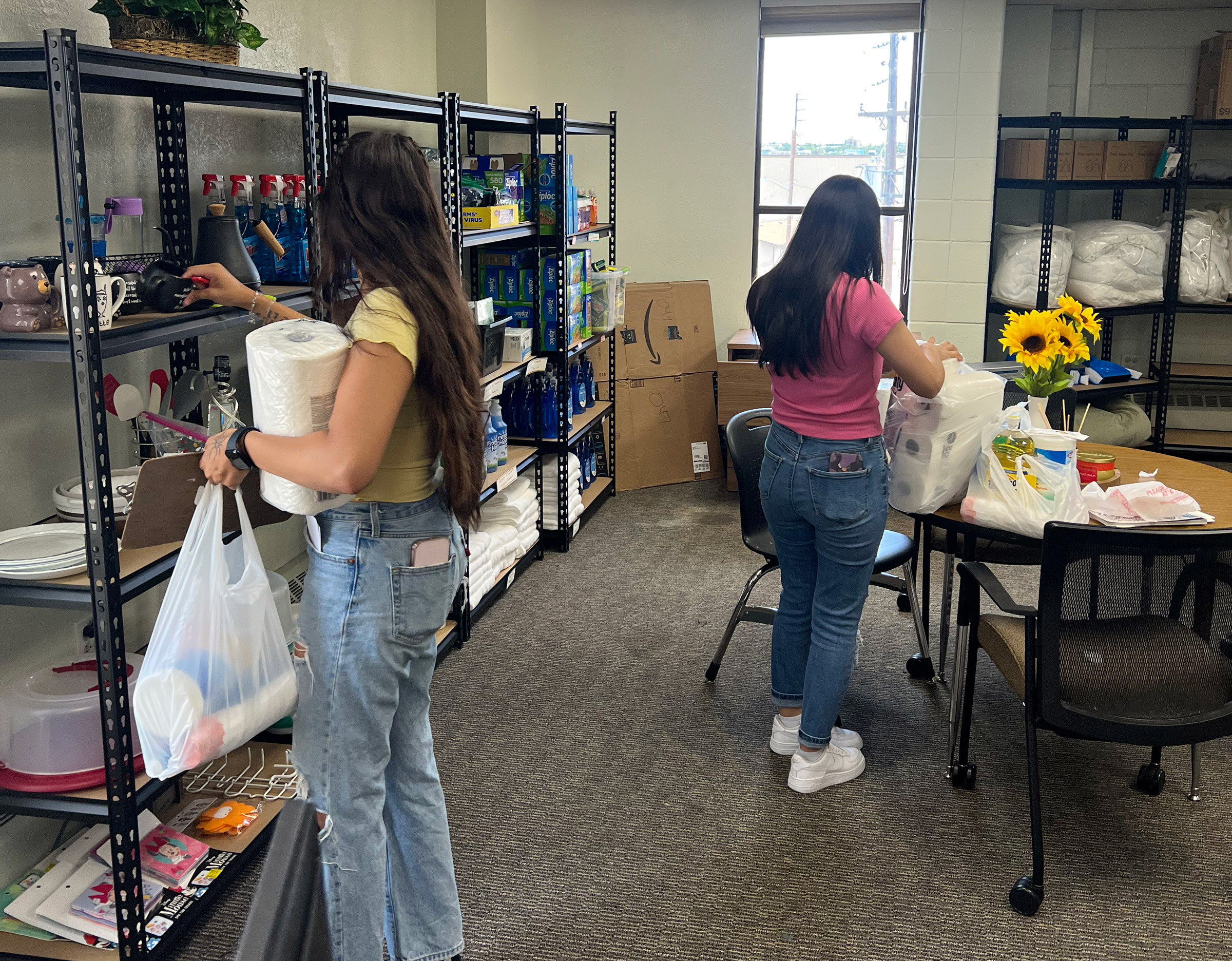 Two people organizing supplies in a storage room.