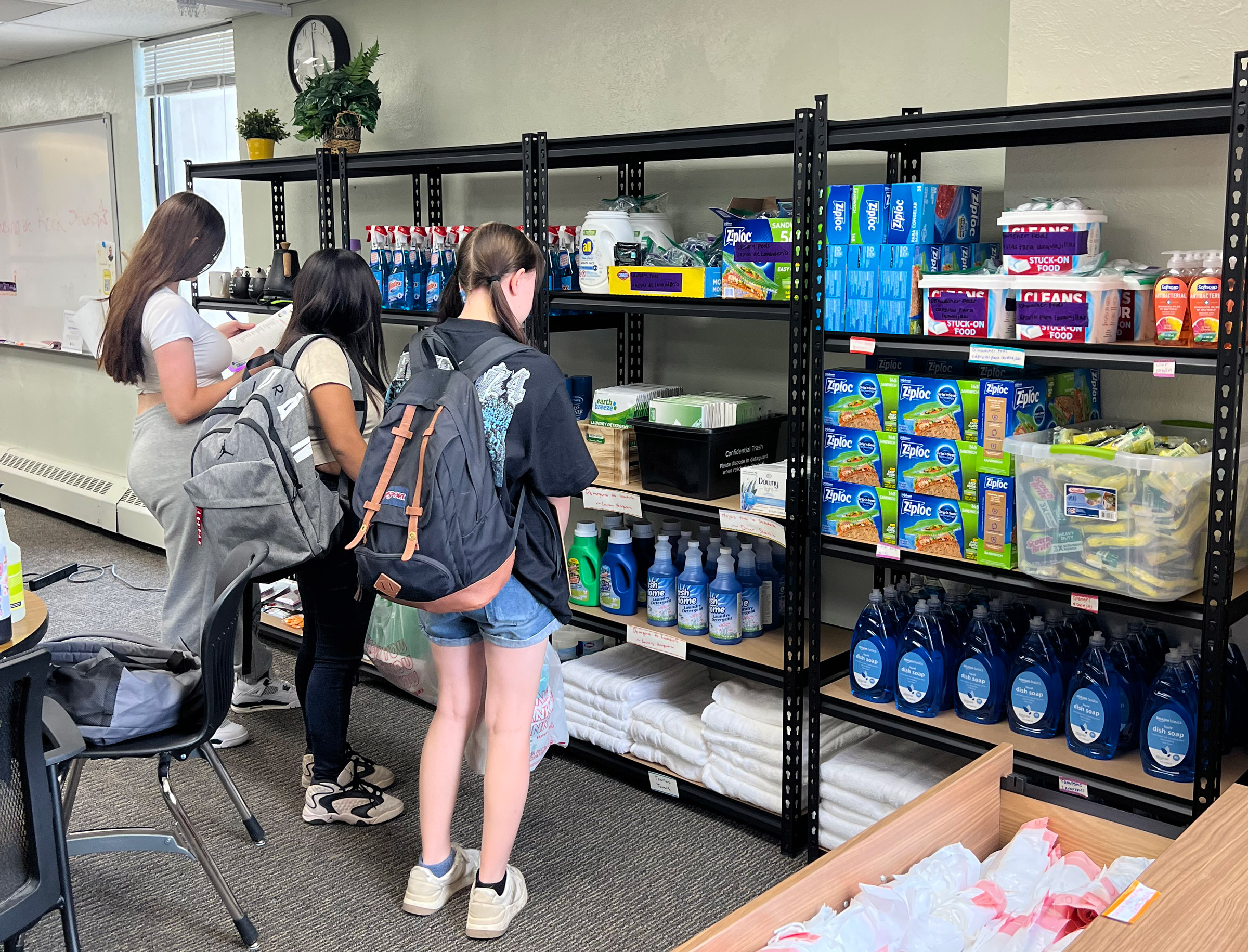 Students browsing shelves of household supplies.