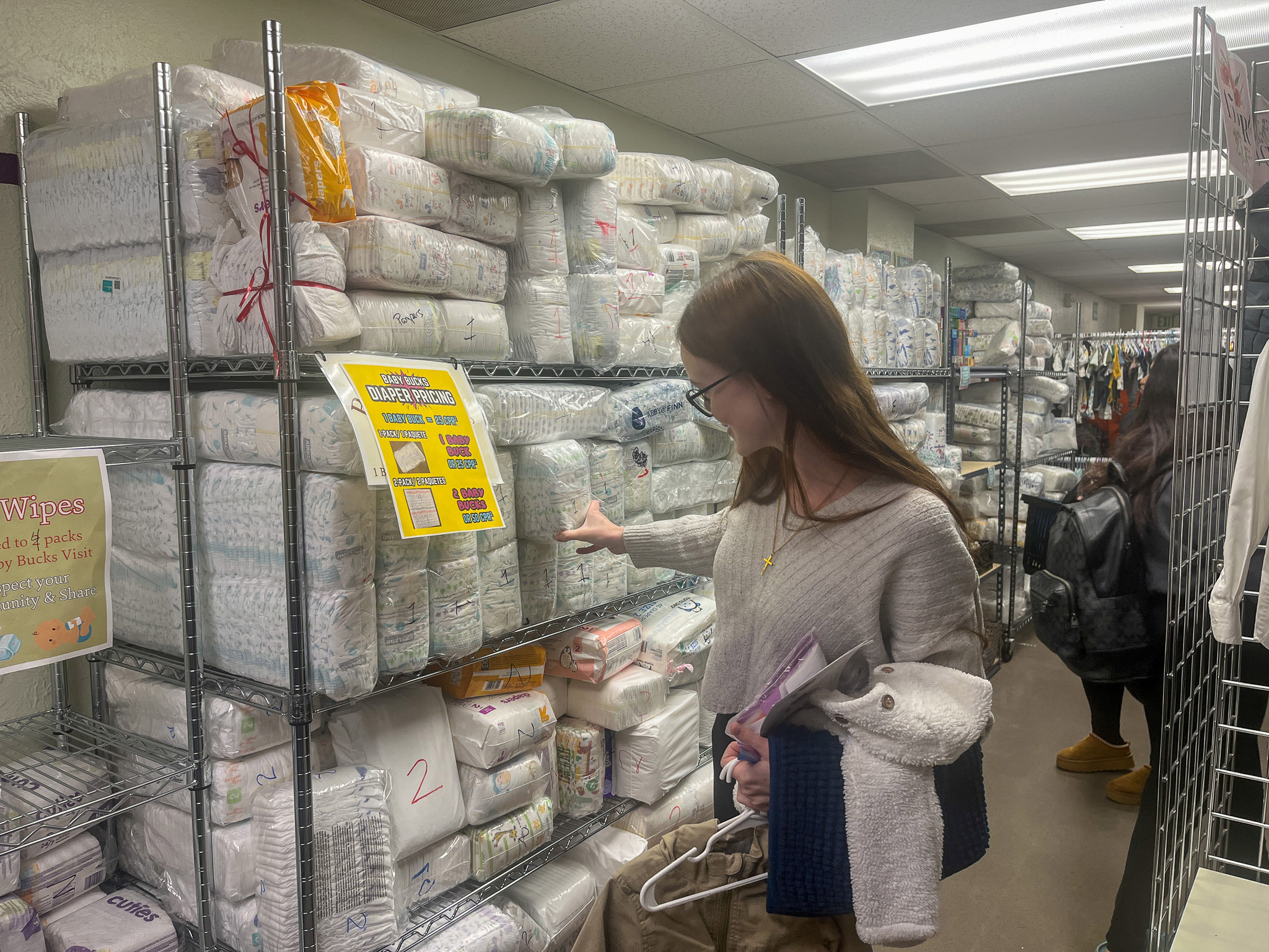 Woman shopping for diapers in a store.