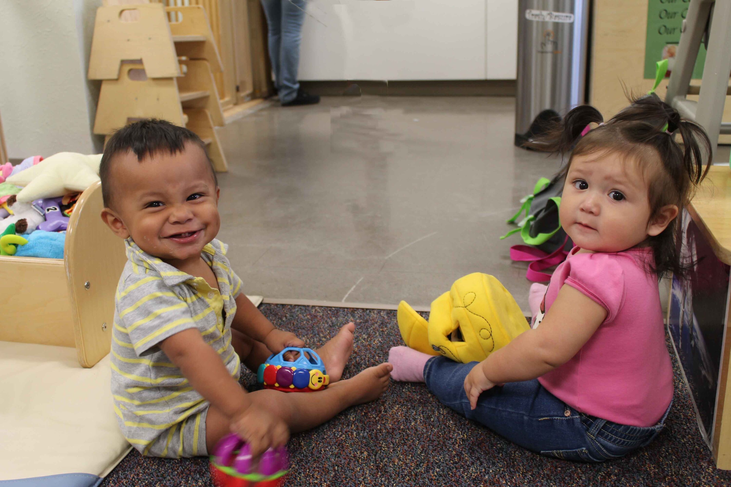 Two toddlers playing with toys indoors