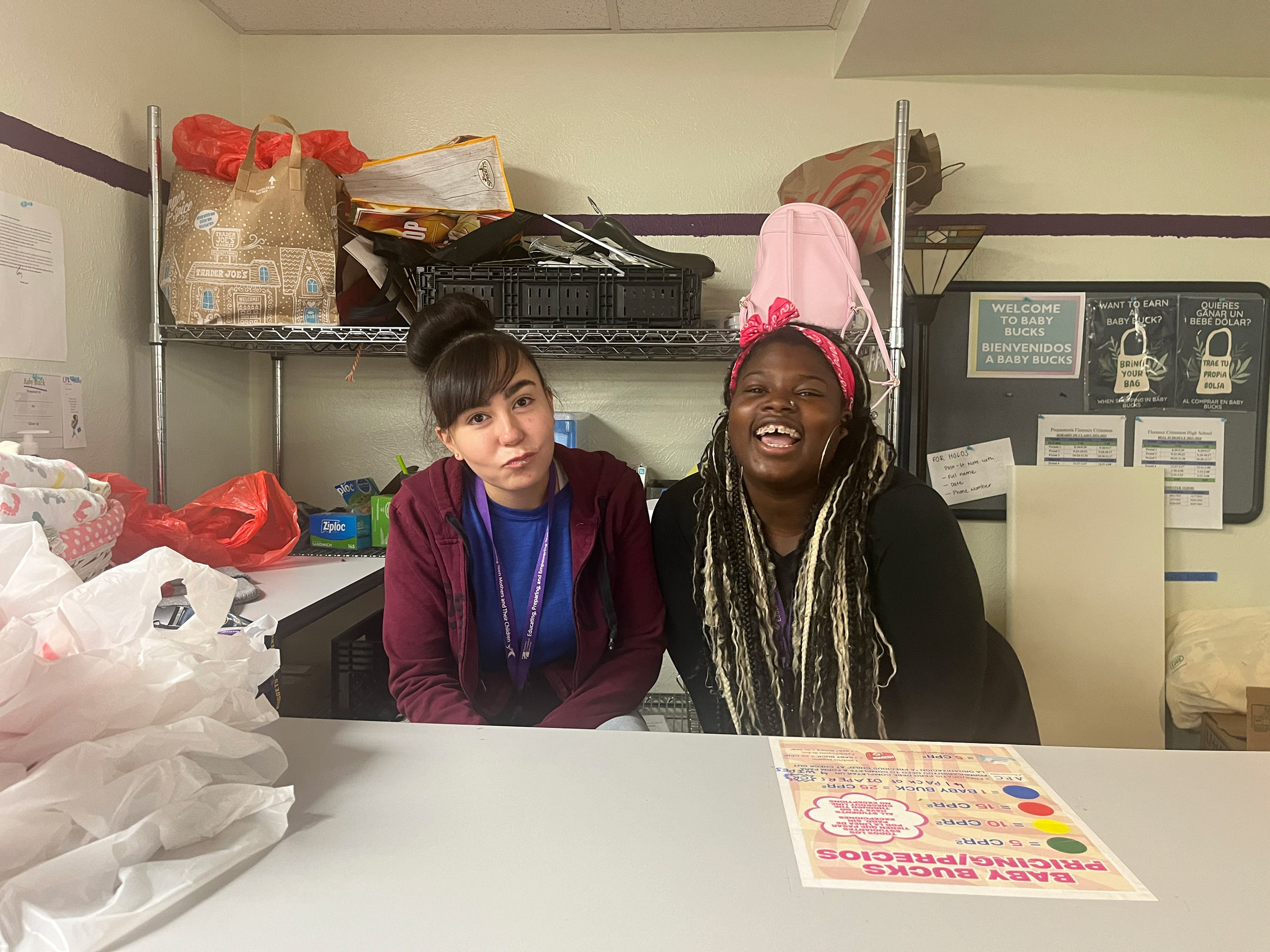 Two women smiling in a storage room