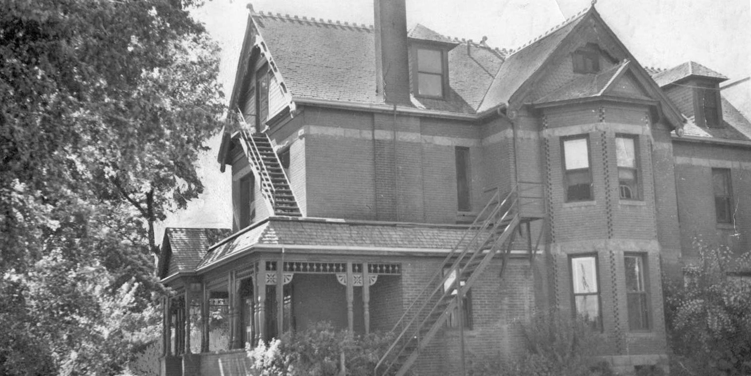 Historic brick house with ornate trim and staircase.