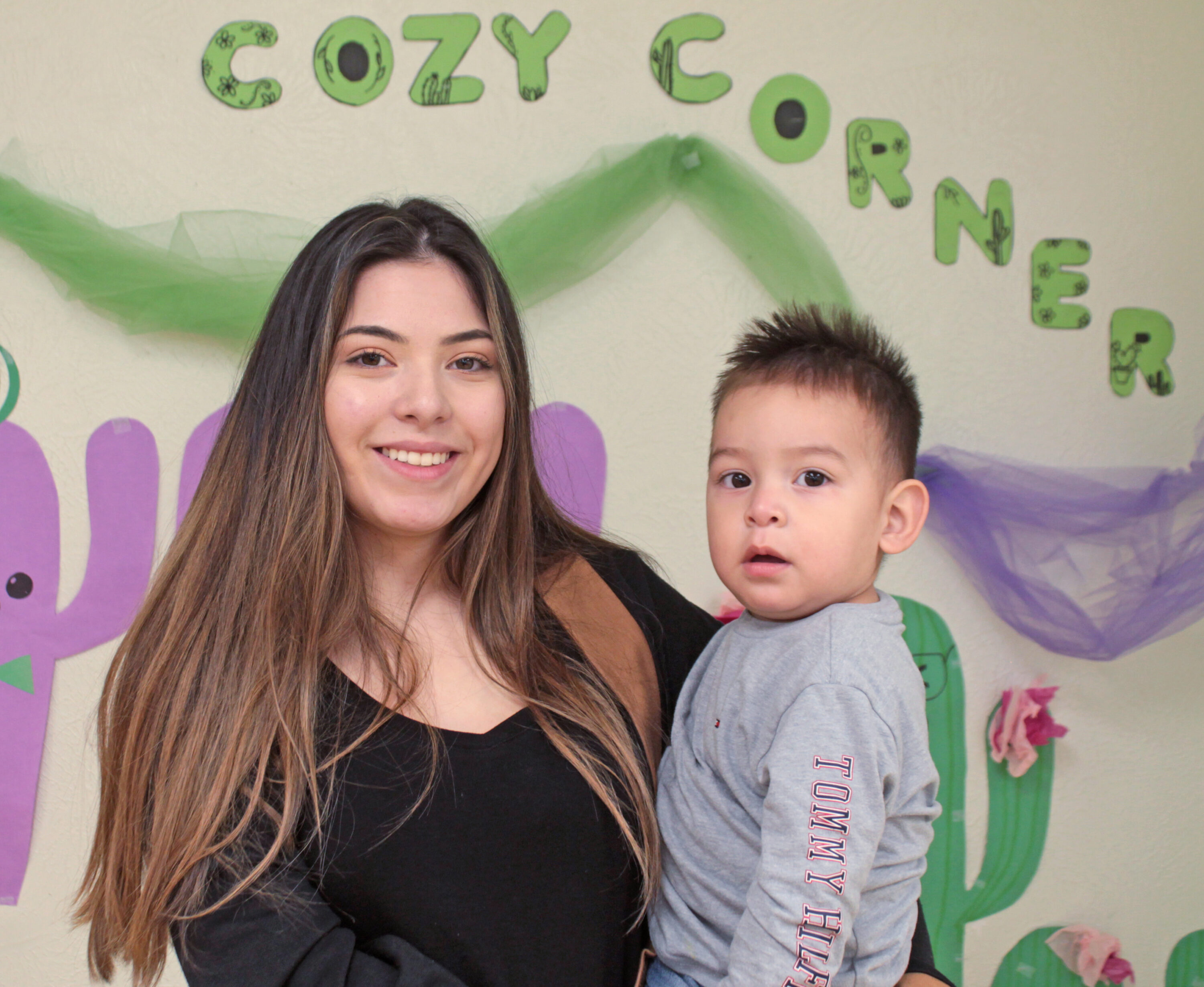 Woman smiling with child at Cozy Corner.