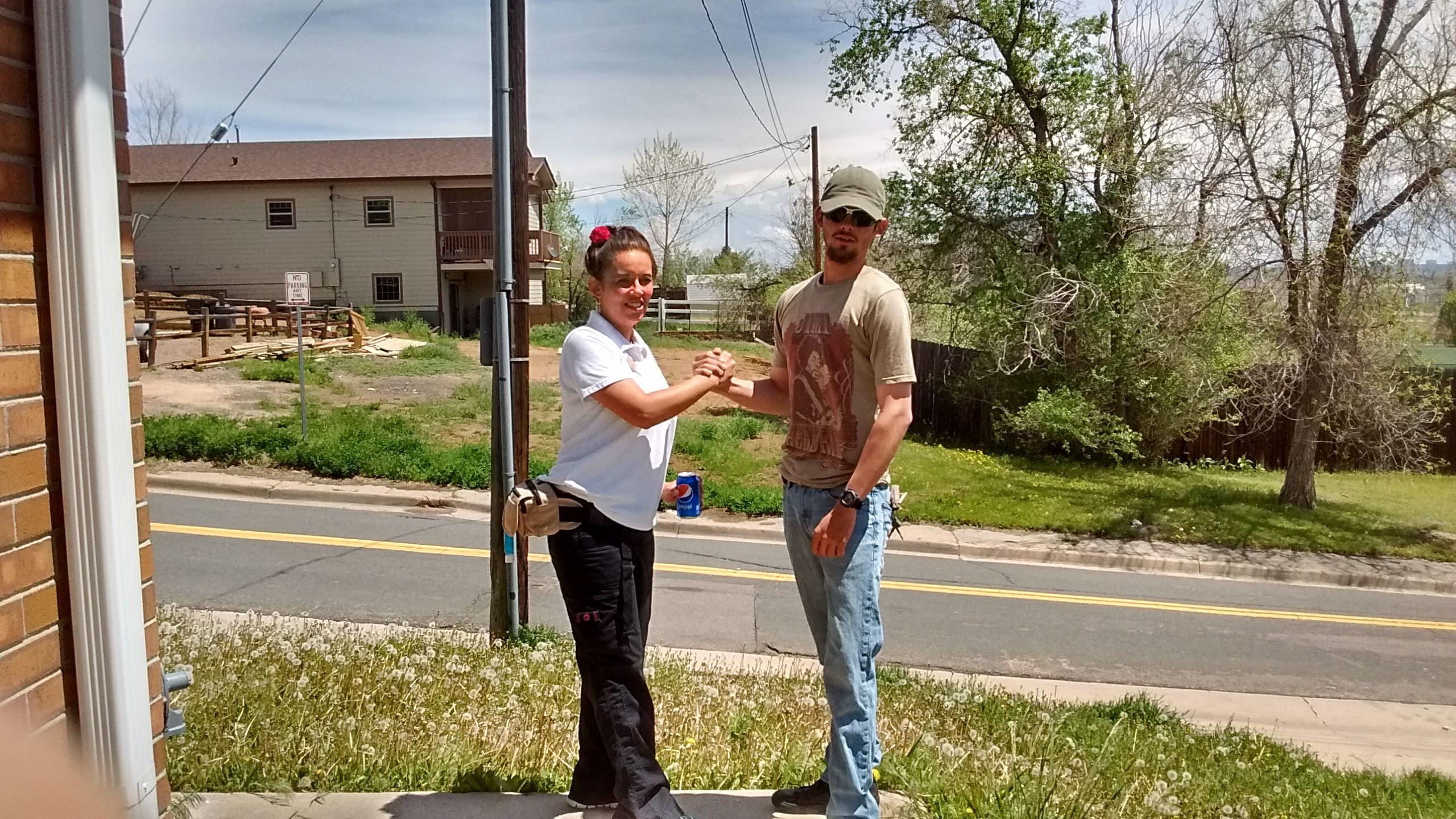 Two people shaking hands outdoors.