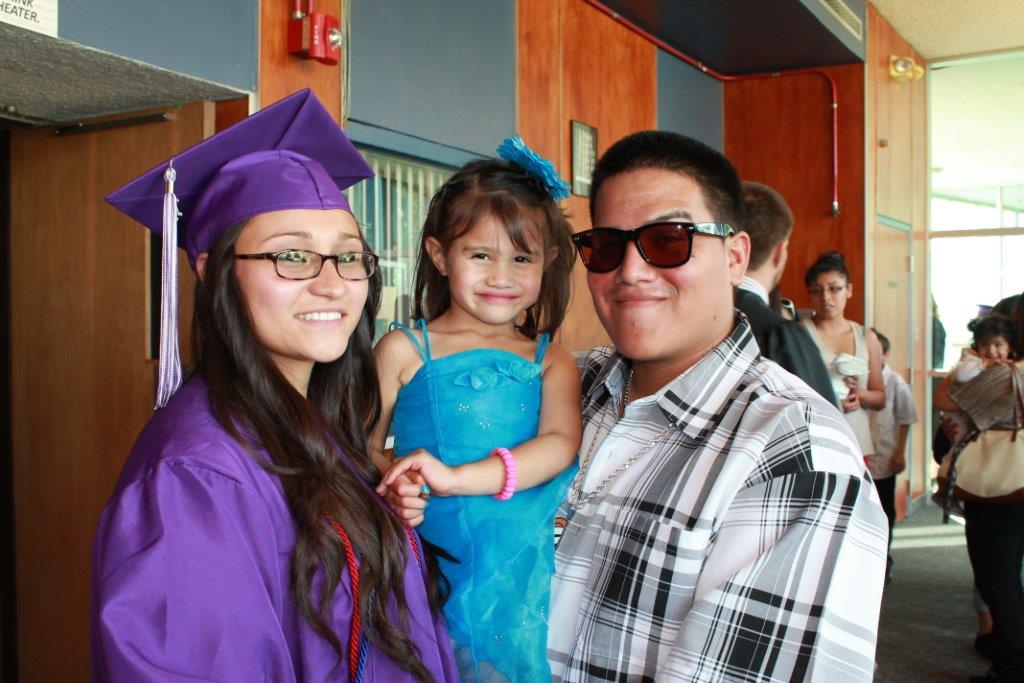 Graduation ceremony with family and graduate in purple.