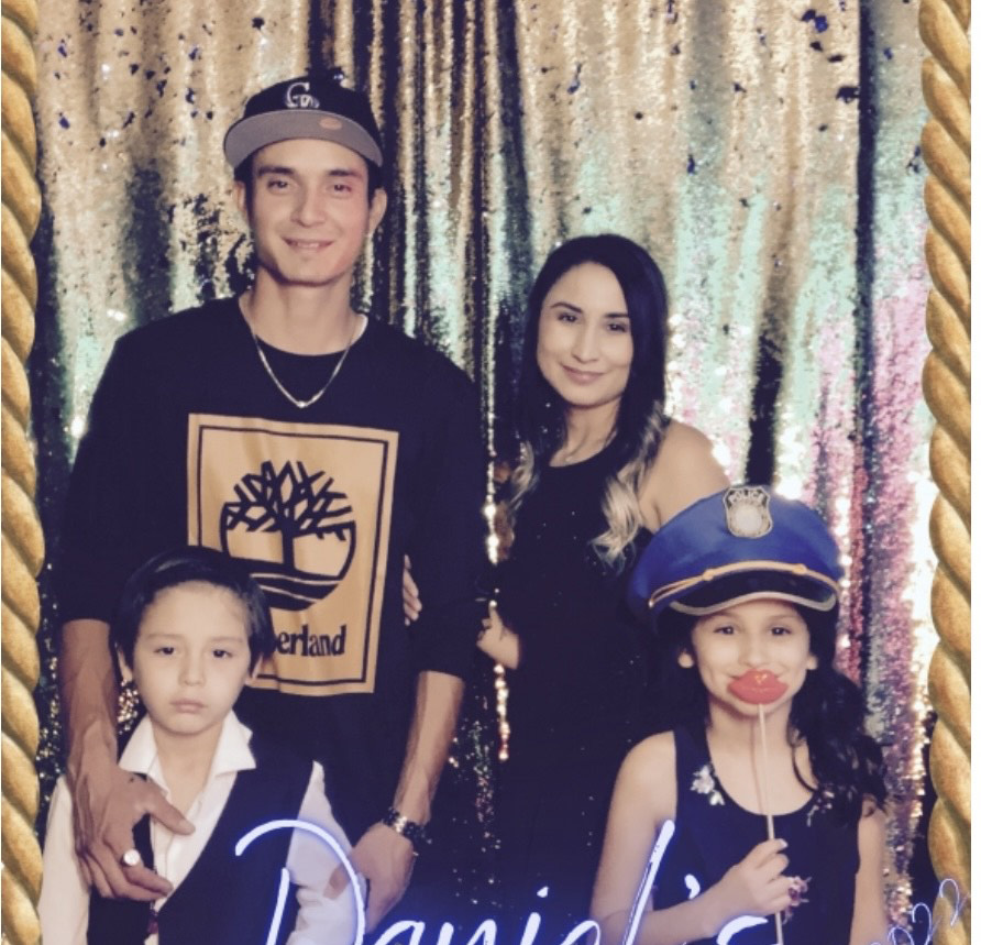 Family posing at a festive event with props