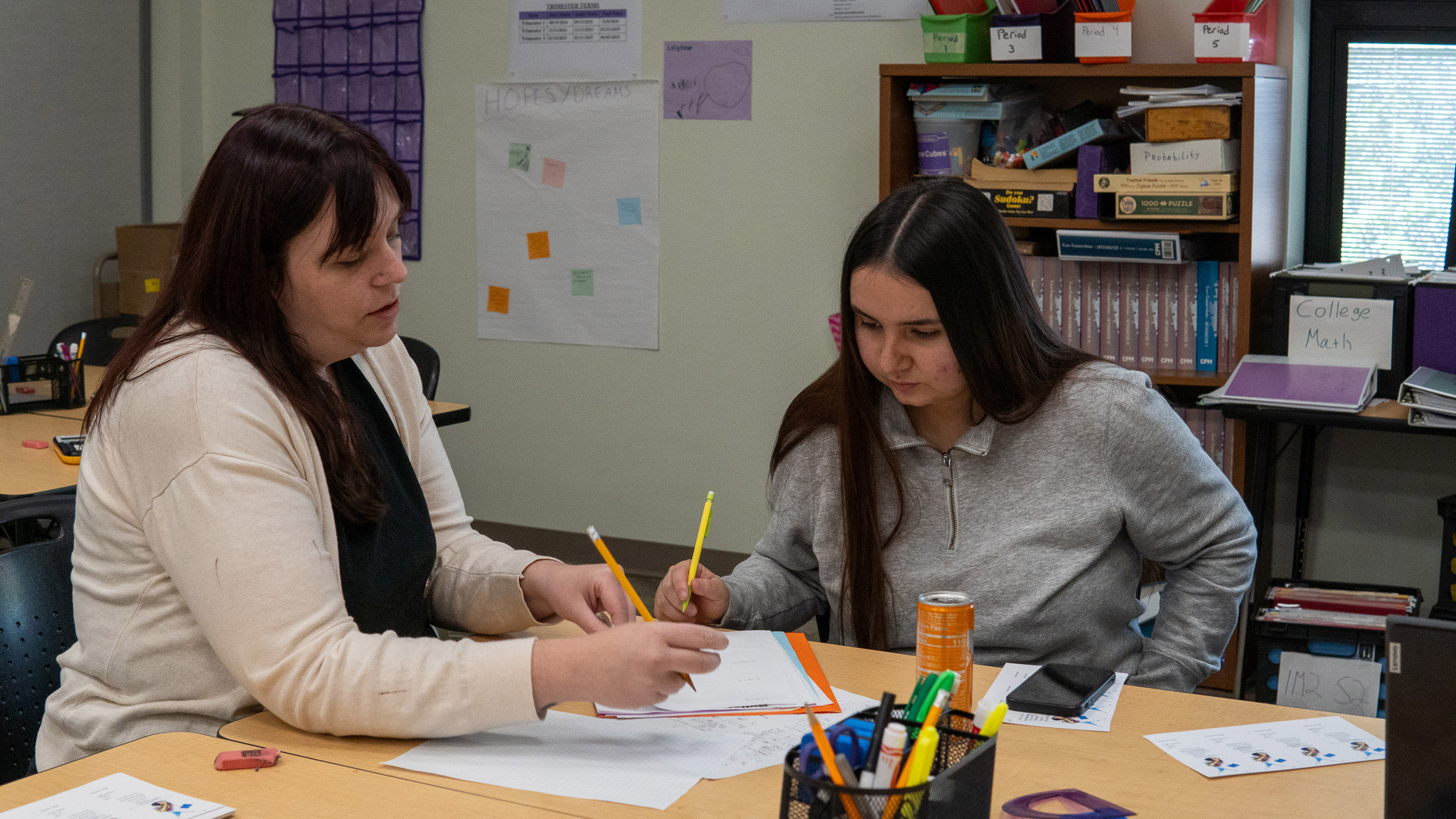 Teacher assisting student in classroom.