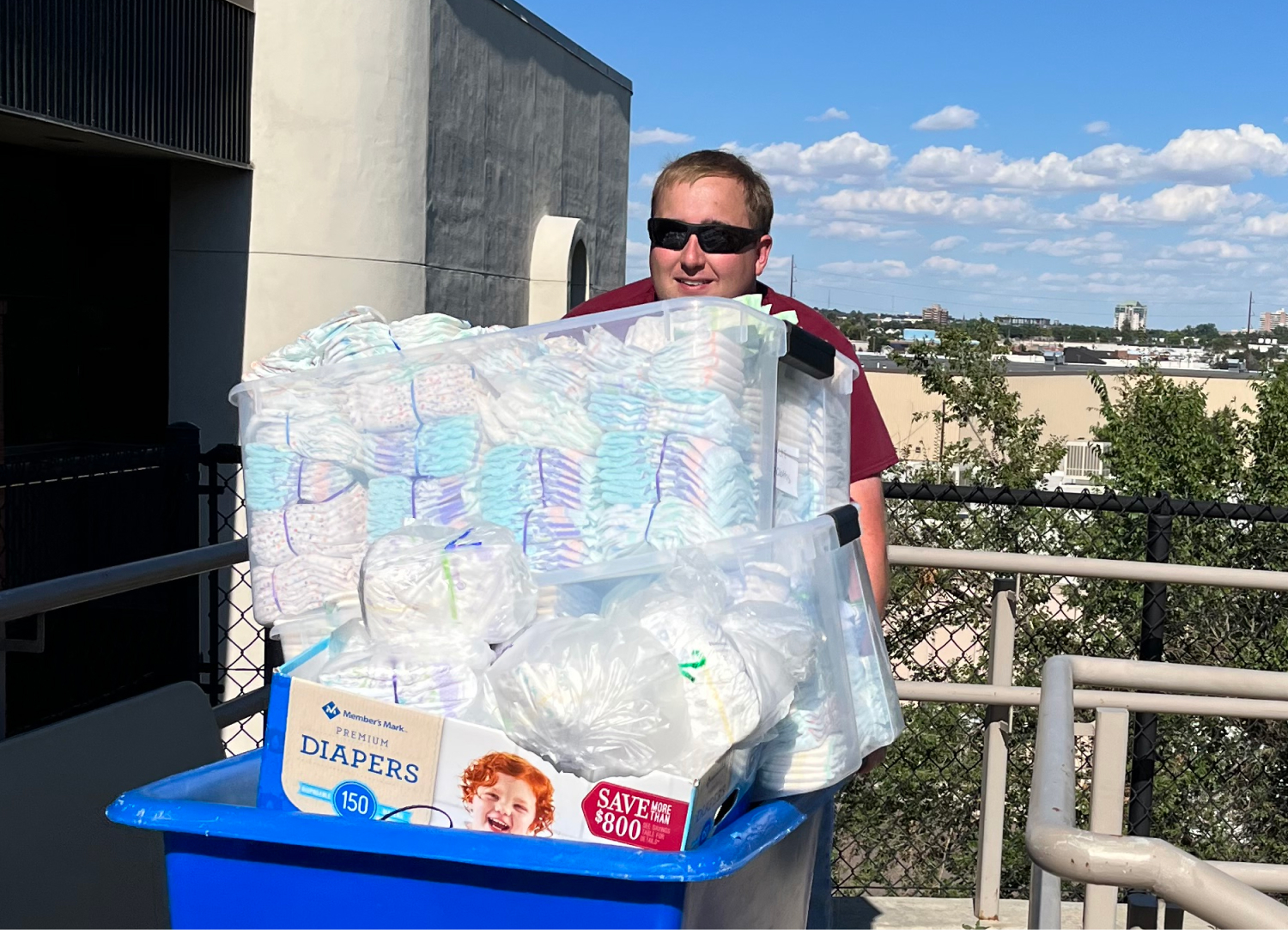 Person pushing container filled with diapers outdoors.